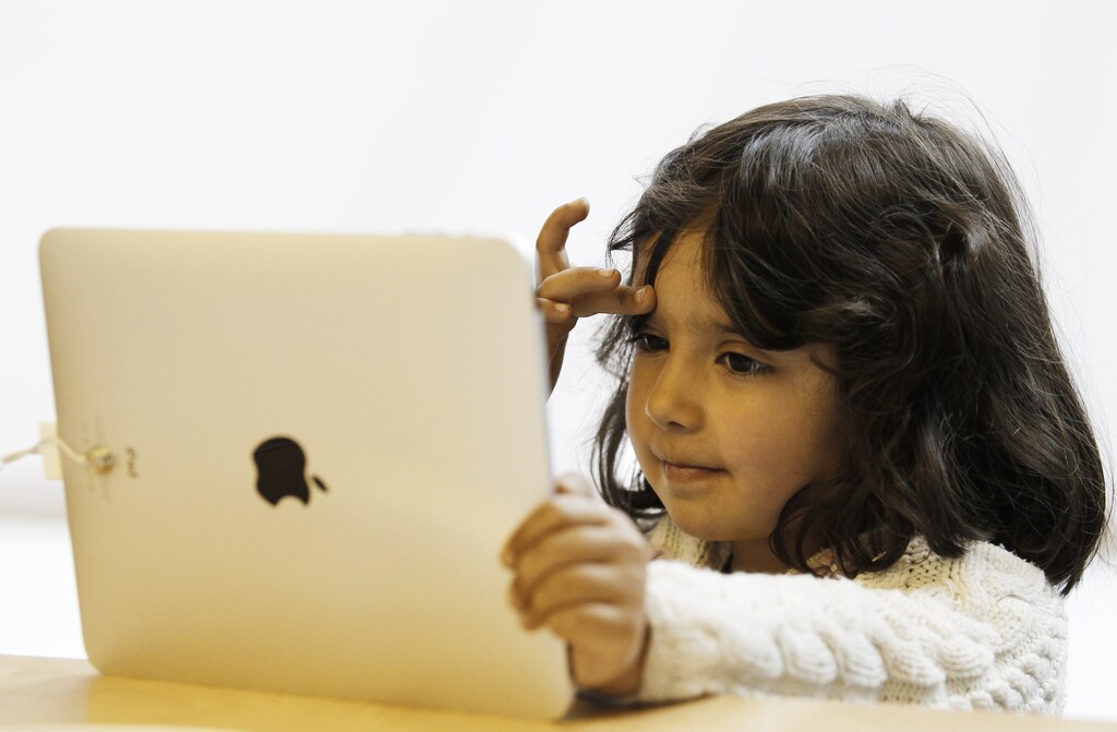 A girl views a new iPad tablet computer at an Apple store during its UK launch in central London May 28, 2010. Diehard fans mobbed Apple Inc stores in Asia and Europe as the iPad tablet computer went on sale outside the United States for the first time on Friday. The device, a little smaller than a letter-size sheet and with a colour touchscreen, is designed for surfing the Web, watching movies and reading. It has been hailed by the publishing industry as a potential life-saver. REUTERS/Luke MacGregor (BRITAIN - Tags: BUSINESS SOCIETY SCI TECH) - RTR2EH16