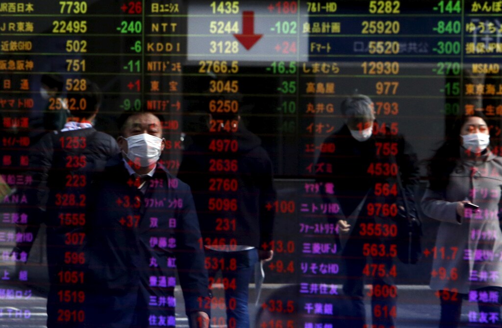 Pedestrians are reflected in an electronic board displaying various stock prices at a brokerage in Tokyo, Japan, February 4, 2016. Asian shares rebounded on Thursday as speculation the U.S. Federal Reserve might opt to not raise interest rates at all this year hammered the dollar and sparked a huge rally in oil prices. REUTERS/Yuya Shino - RTX25D0D