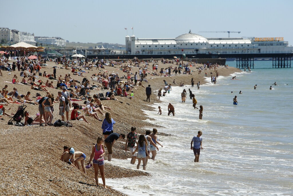 Sunbathers and swimmers enjoy a hot Summer day at Brighton beach in Britain June 30, 2015. Britain's Meteorological Office has warned of the possibility of heatwave conditions, with temperatures reaching their highest of the year on Tuesday and Wednesday. REUTERS/Luke Macgregor - LR2EB6U0ZPAD0