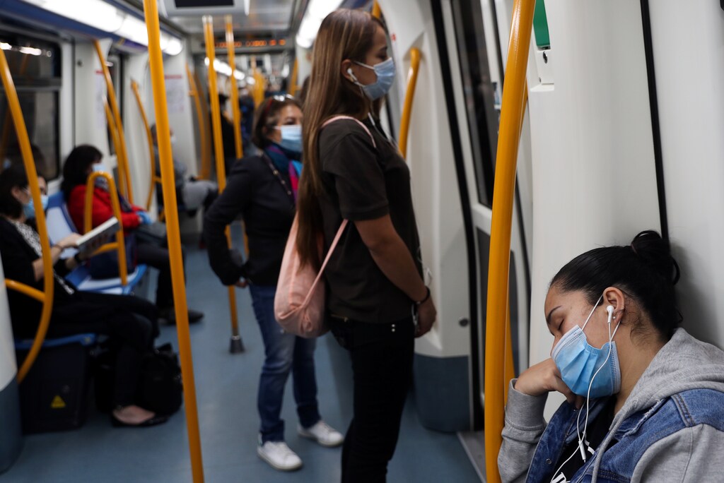 A commuter wearing a protective mask sleeps inside a metro coach, on the first day mask usage is mandatory in public transport, amid the coronavirus disease (COVID-19) outbreak in Madrid, Spain, May 4, 2020. REUTERS/Susana Vera - RC2KHG9NML78