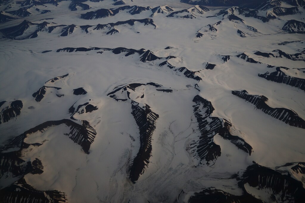 An aerial view shows snow-covered mountains in Svalbard, Norway, August 3, 2019. REUTERS/Hannah McKay SEARCH "SVALBARD CLIMATE" FOR THIS STORY. SEARCH "WIDER IMAGE" FOR ALL STORIES. - RC19BA07B8A0