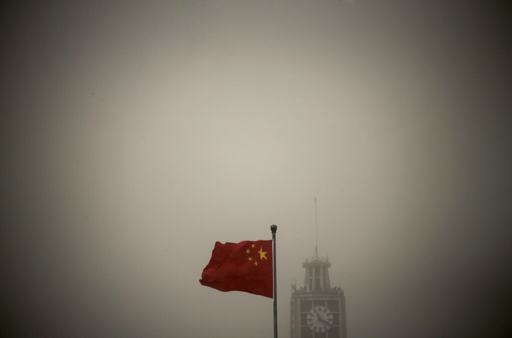 A Chinese national flag flies in front of Beijing Telegraph Building on a hazy morning in central Beijing, February 28, 2013. Beijing's environmental authorities said on Thursday air quality in Beijing and nearby regions hit dangerous levels, Xinhua News Agency reported. REUTERS/Petar Kujundzic (CHINA - Tags: ENVIRONMENT TPX IMAGES OF THE DAY) - GM1E92S186Z01