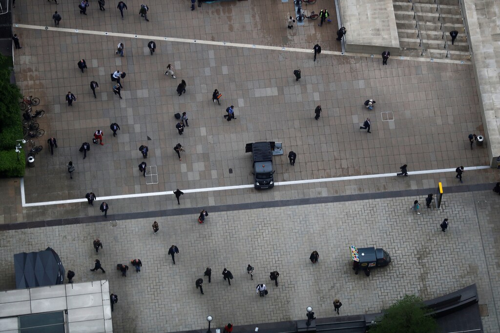 People walk accross a plaza in the Canary Wharf financial district in London, Britain May 17, 2017. REUTERS/Stefan Wermuth - RTX366NC