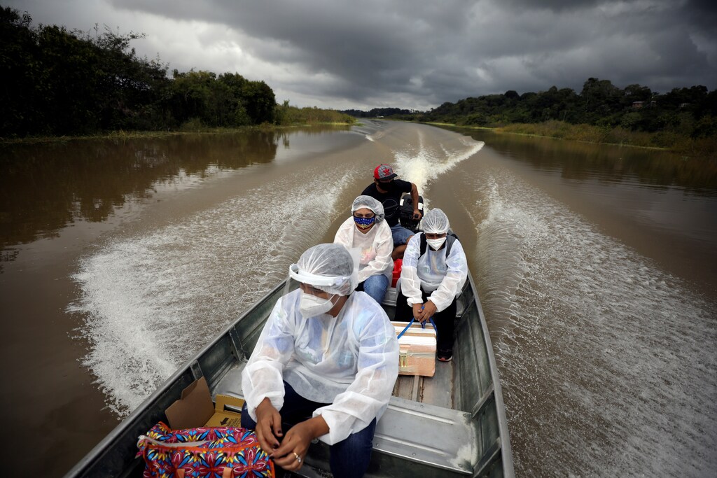Municipal health workers travel on a boat along the Solimoes river banks, where Ribeirinhos (river dwellers) live, to administer the AstraZeneca/Oxford vaccine for the coronavirus disease (COVID-19) to the residents, in Manacapuru, Amazonas state, Brazil, February 1, 2021. Picture taken February 1, 2021. REUTERS/Bruno Kelly TPX IMAGES OF THE DAY - RC24LL9N5T2J