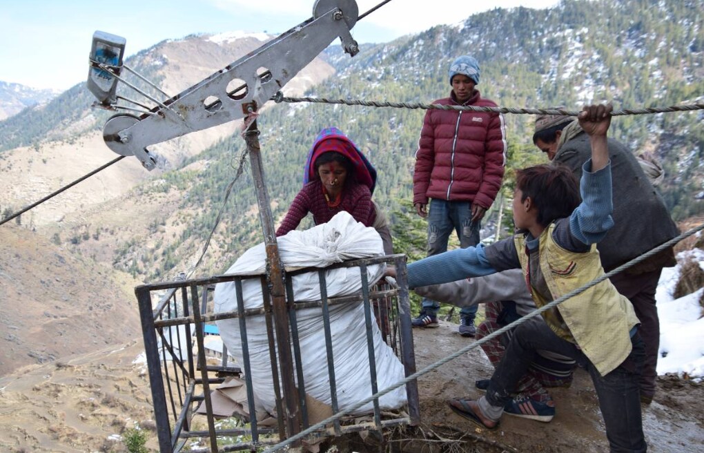 Belkosha Bohora loads produce into a gravity-assisted rope-and-cable system that lets women transport heavy loads to market without carrying them on their backs, in Ratada, Nepal, February 5, 2019. Credit: Archana Gurung, Practical Action