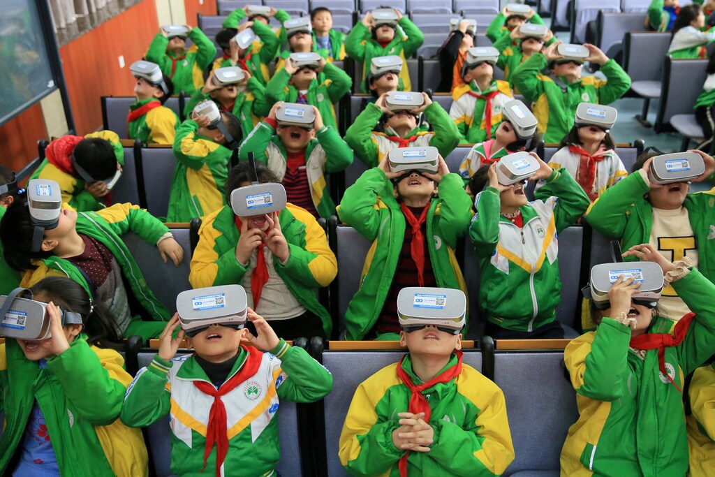 Primary school students wear virtual reality (VR) headsets inside a classroom in Xiangxi Tujia and Miao Autonomous Prefecture, Hunan province, China March 14, 2018. Picture taken March 14, 2018. REUTERS/Stringer