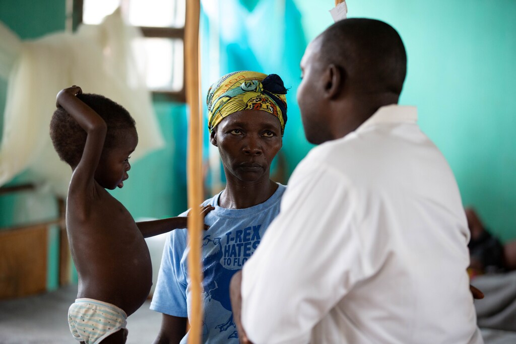 Three-year-old Eme Mbisa, who has become malnourished as a result of a measles infection, rests her hand on the shoulder of her mother, Marianne Mbisa, as she talks to a doctor in the measles isolation ward in Boso-Manzi hospital in Mongala province in northern Democratic Republic of Congo February 29 , 2020. Picture taken February 29 , 2020. REUTERS/Hereward Holland - RC2LPF92U3B4