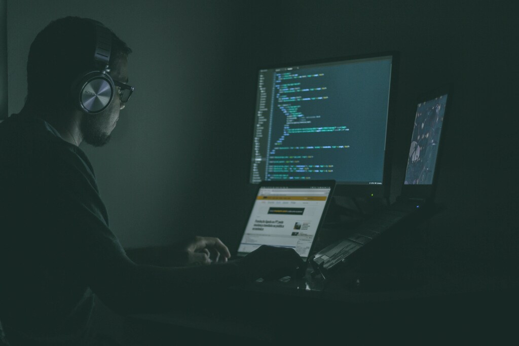 Person using laptop, computer monitor and headphones: A cybersecurity workforce must be diverse and plug the skills gap.