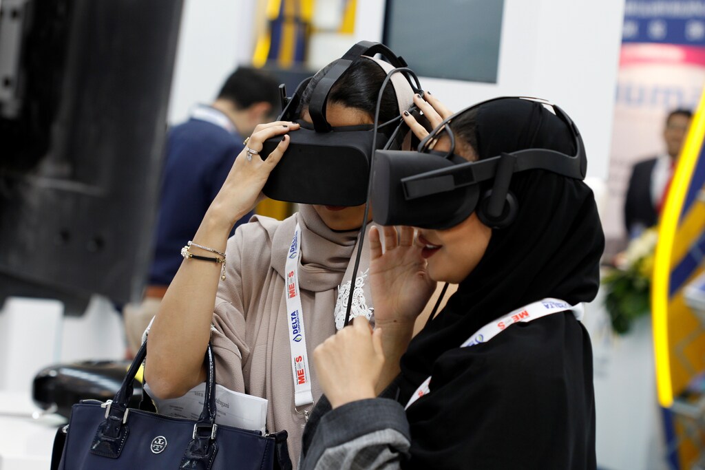 Saudi women wearing Virtual Reality goggles experiencing SAUDI ARAMCO oil plant tour during the 20th Middle East Oil & Gas Show and Conference (MOES 2017) in Manama, Bahrain, March 7, 2017.