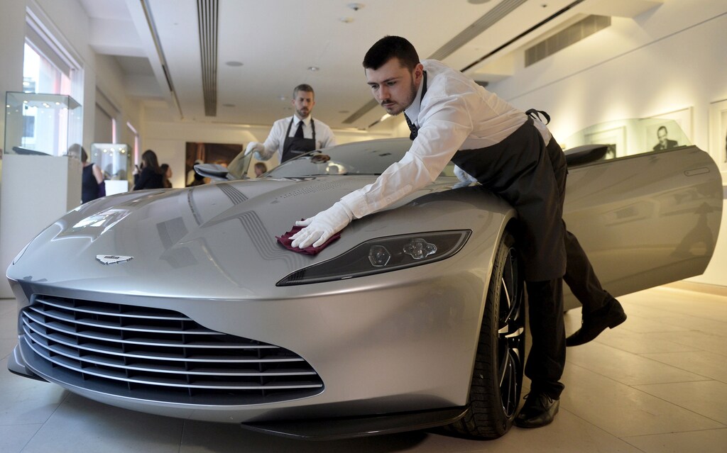 Employees polish an Aston Martin DB10, one of the series of DB10s designed and engineered by Aston Martin for the James Bond film "Spectre", during a media preview of "Spectre - the Auction", at Christie's auction house in London February 15, 2016. REUTERS/Hannah McKay/File Photo GLOBAL BUSINESS WEEK AHEAD PACKAGE - SEARCH 'BUSINESS WEEK AHEAD MAY 30' FOR ALL IMAGES - S1BETGXRGIAB