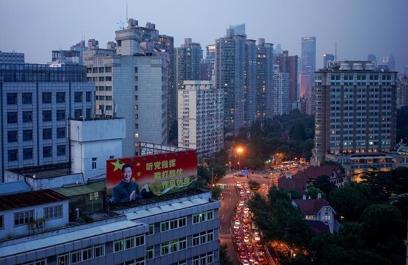 A poster with a portrait of Chinese President Xi Jinping overlooks a street at sunset in Shanghai, China, September 26, 2017. The slogan reads: "Follow the Party's command. Be capable of winning wars. Maintain good discipline." Picture taken September 26, 2017. REUTERS/Aly Song - RC16F6651650