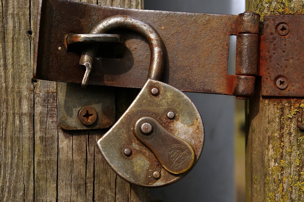 a rusty padlock on a wooden door; Trust remains the ultimate currency in wealth management