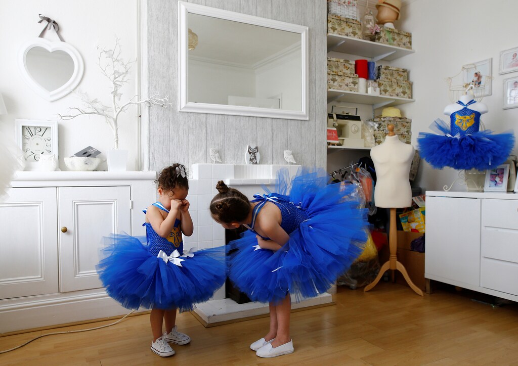 Milli Astill, age 7, attempts to persuade 3-year old Lissi-Lu to have her photograph taken with her in their Leicester City tu-tus in Leicester, Britain April 22, 2016. Leicester City's Premier League title dream became reality on Monday as their only remaining challengers Tottenham Hotspur drew 2-2 at Chelsea to complete one of the greatest ever sporting achievements.The Foxes' Premier League campaign has captivated fans in the provincial English city as well as sports fans worldwide. REUTERS/Darren Staples SEARCH "STAPLES FOXES" FOR THIS STORY. SEARCH "THE WIDER IMAGE" FOR ALL STORIES TPX IMAGES OF THE DAY - S1BETBXGOKAA