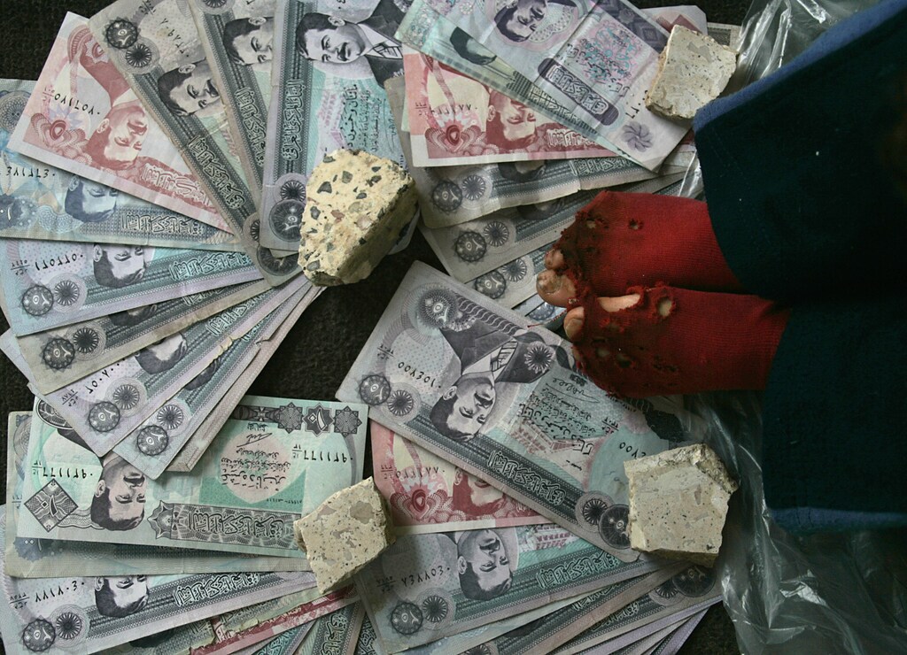 An Iraqi boy sells Iraqi dinars as war souvenirs on a street in downtown Amman February 6, 2007. Sectarian cleansing in Iraq was causing the widest movement of displaced people on a scale unseen since the Kosovo civil war, Rafiq Tschannen, chief of mission of Iraq for the Geneva-based mission for the International Organisation for Migration (IOM), said on Tuesday. REUTERS/Ali Jarekji (JORDAN) - GM1DUOACKLAA