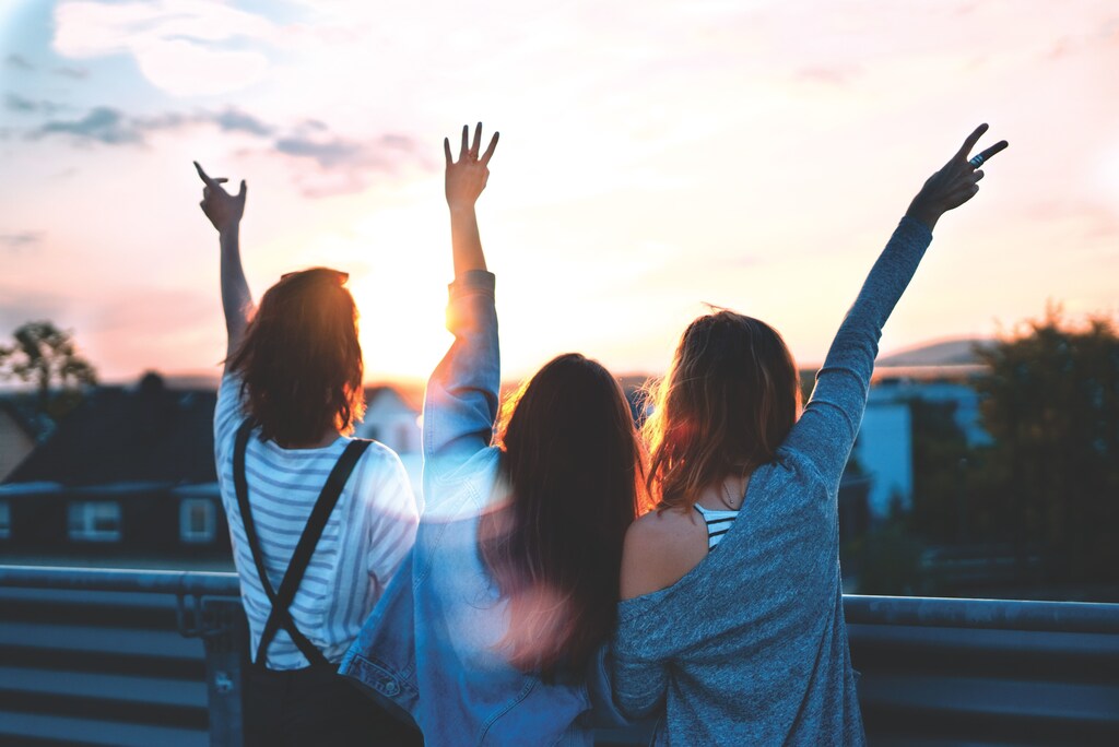 Three young women enjoying a sunset.