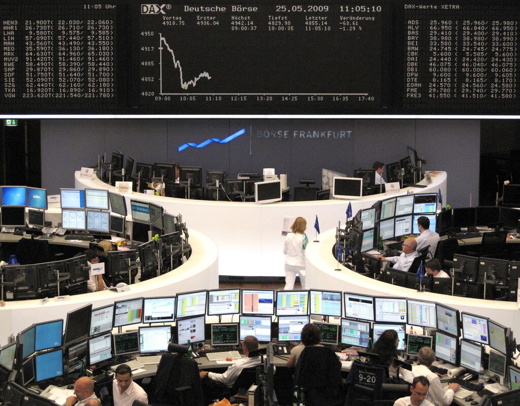 Traders work at their desks in front of the DAX board at the Frankfurt stock exchange May 25, 2009. REUTERS/Remote/Pawel Kopczynski (GERMANY BUSINESS) - BM2E55P0UXS01