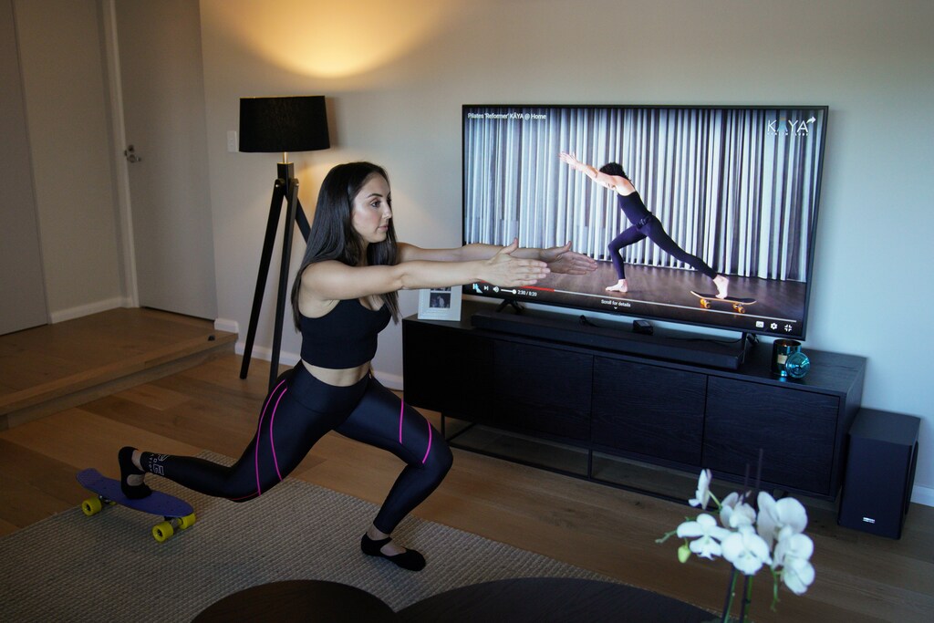 Alexandra Gallo, residente de Sydney, utiliza una clase de Pilates en patineta guiada que se encuentra en línea para hacer ejercicio dentro de su casa, ya que el estudio de Pilates al que solía asistir cerró debido a las restricciones de las reuniones sociales implementadas para frenar la propagación de la enfermedad del coronavirus (COVID-19), en Sydney, Australia, el 17 de abril de 2020.