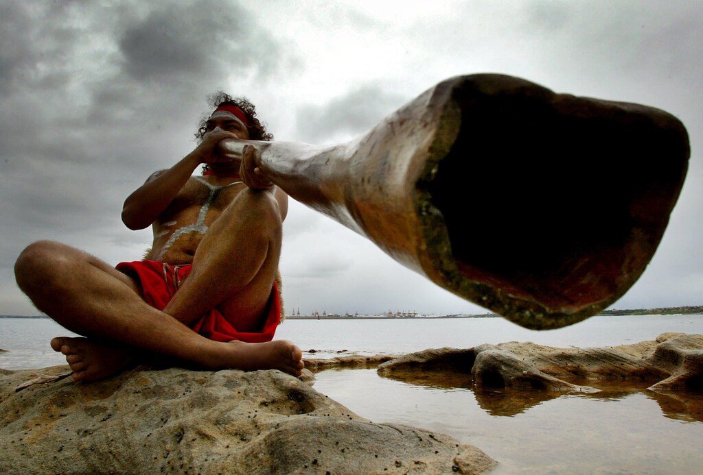 Aboriginal peformer Les Saxby plays a traditional aboriginal musical instrument known as a didgeridoo on the shores of Sydney's Botany Bay April 29, 2002 during the Meeting of Two Cultures ceremony. [The annual ceremony celebrates at the exact spot where 232 years ago the famous British explorer James Cook landed upon Australia, and is attended by local community groups as part of the ongoing reconciliation process with the local indigenous cultures.] - PBEAHUKSRBK
