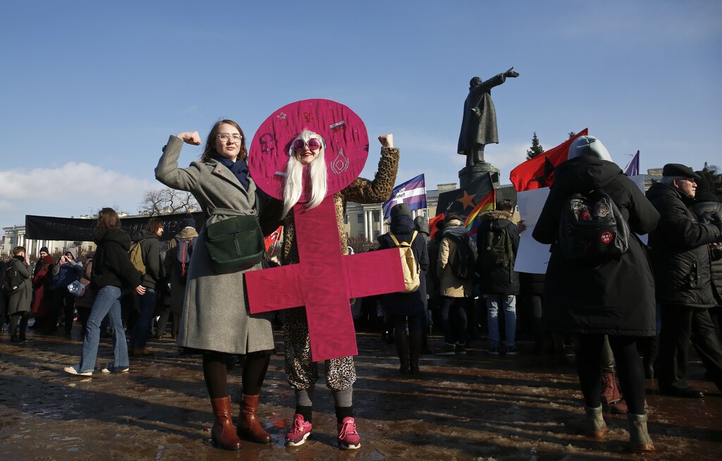 People attend a rally, held to support women's rights and to protest against violence towards women, with a monument to Soviet state founder Vladimir Lenin seen in the background, in Saint Petersburg, Russia March 8, 2019. REUTERS/Anton Vaganov - UP1EF38114D0M