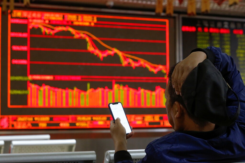 An investor sits in front of displays showing stock information at a brokerage office in Beijing, China October 11, 2018