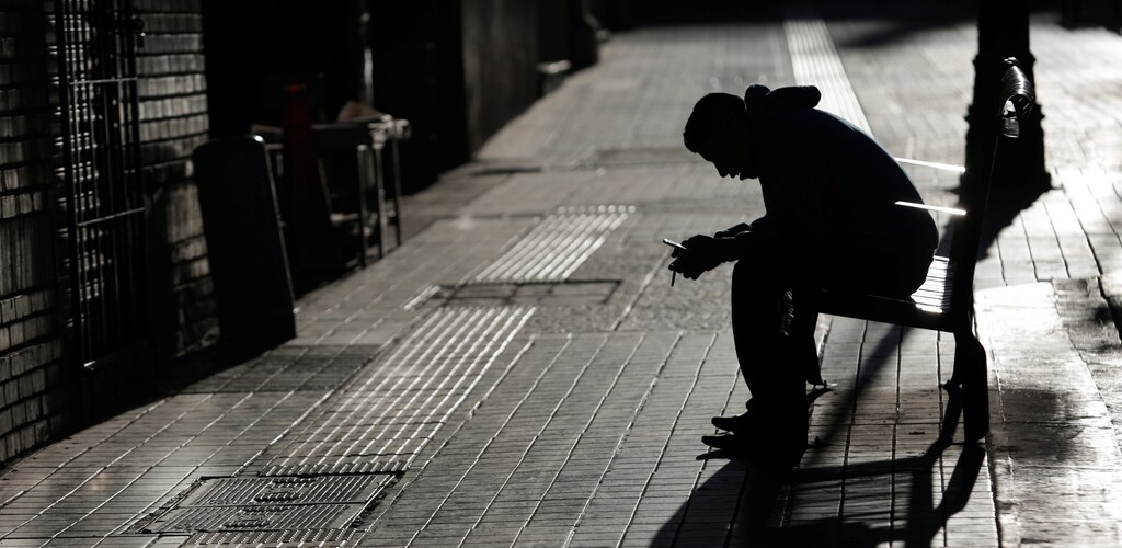 A man checks his phone while sitting on a bench in Saltillo, Mexico, November 30, 2017.