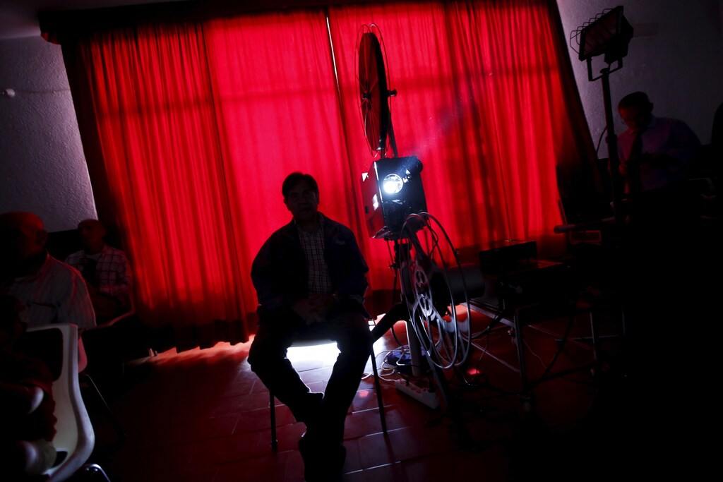 Projectionist Antonio Feliciano, 75, shows a film during a projection in Monforte, Portugal May 16, 2015. Shades of Oscar-winning classic "Cinema Paradiso" run through the life of Feliciano, a sprightly 75-year-old who fears he may be the last of Portugal's travelling film projectionists. After six decades travelling four million km (2.5 million miles) to screen 4,000 films in Portugal's far-flung villages, Feliciano does not plan to retire just yet. But he is resigned to the fact that the Internet, digital TV and distribution monopolies have made his craft obsolete. Picture taken May 16, 2015. REUTERS/Rafael Marchante - GF20000051556