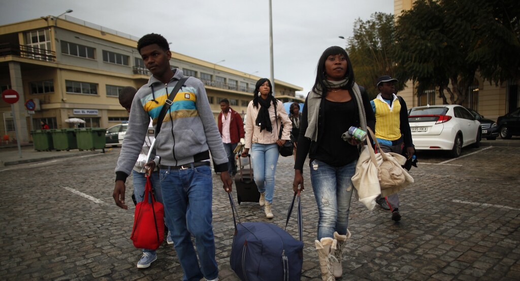 African migrants walk with their luggage after arriving from Melilla on a passenger ferry at Malaga port, southern Spain, April 3, 2014.
