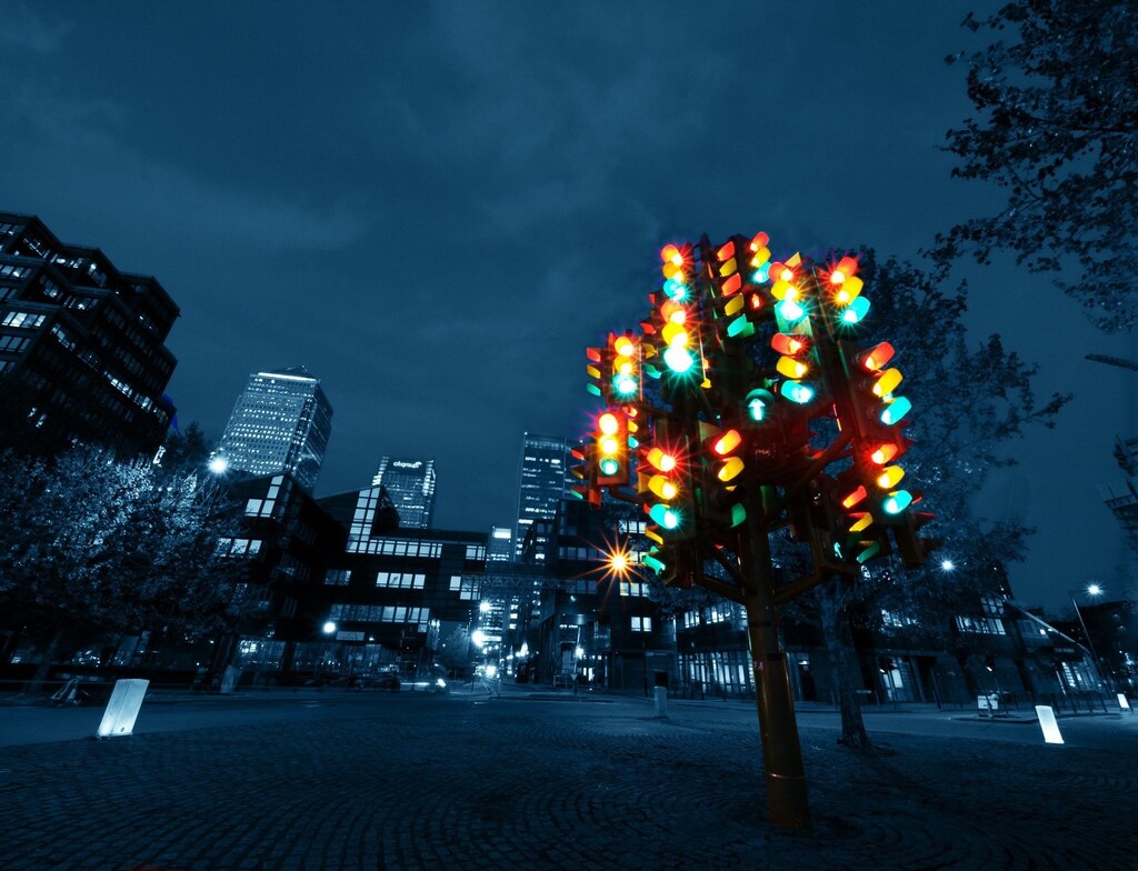 Traffic lights in a tree formation against a city skyline