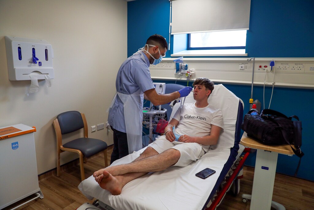 Patient Chay Godfrey is treated by staff nurse Elia Sarno in the Emergency Department at Wexham Park Hospital near Slough, Britain, May 22, 2020. Picture taken May 22, 2020. Steve Parsons/Pool via REUTERS - RC2XWG9NG0V2