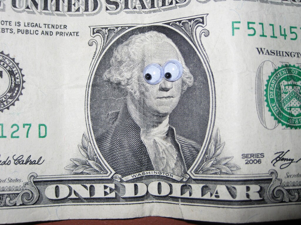 A dollar bill with cartoon eyes