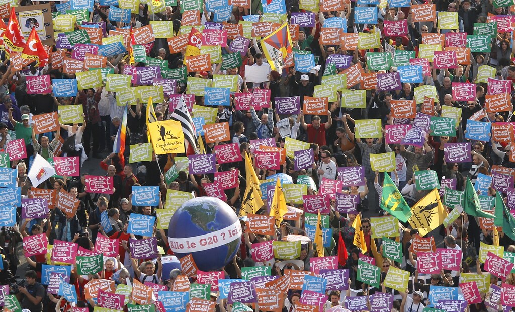 General view as anti G20 demonstrators hold up signs near a sphere decorated as the planet with the message, "Hello, the G20?" as they take part in a protest march against globalisation in Nice, southeastern France, November 1, 2011. G20 leaders will gather in Cannes for the final Summit of France's presidency November 3-4. REUTERS/Eric Gaillard (FRANCE - Tags: POLITICS BUSINESS) - RTR2THI1