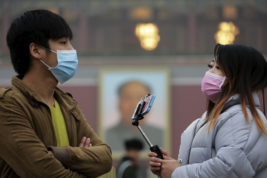 A couple wearing protective masks visit the Tiananmen Gate on an extremely polluted day as hazardous, choking smog continues to blanket Beijing, China December 1, 2015. REUTERS/Damir Sagolj - GF20000080574