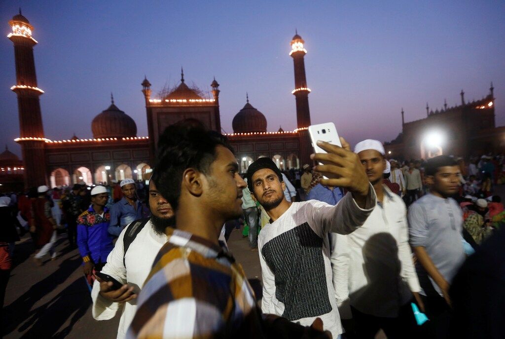 A Muslim man takes a selfie after eating his iftar (breaking fast) meal during the holy month of Ramadan at the Jama Masjid (Grand Mosque) in the old quarters of Delhi, India, May 20, 2018. REUTERS/Adnan Abidi - RC17179E9E00
