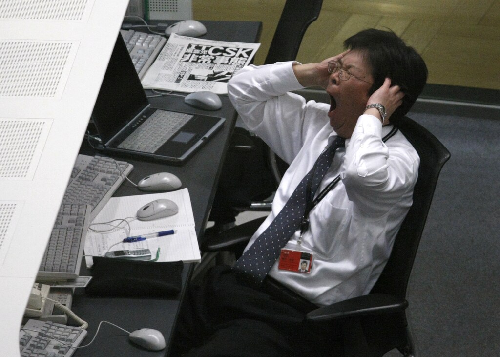 A stock dealer yawns during trading at the Tokyo Stock Exchange in Tokyo March 2, 2009. Japan's Nikkei stock average slid 3.2 percent on Monday, with Mitsubishi UFJ Financial Group and other banks sinking on fears about their U.S. peers, while exporters slipped on worry about the U.S. economy. REUTERS/Issei Kato (JAPAN) - RTXC8XP