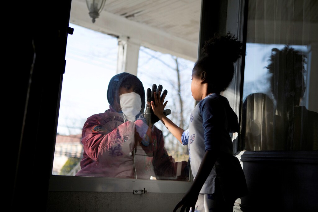 Hashim, an essential worker in the healthcare industry, greets his daughter through the closed door as he maintains social distance from his family as he works amid the coronavirus disease (COVID-19) outbreak in New Rochelle, New York, U.S., April 11, 2020. Picture taken April 11, 2020. REUTERS/Joy Malone TPX IMAGES OF THE DAY REFILE - CORRECTING STATE - RC253G9I4I5B