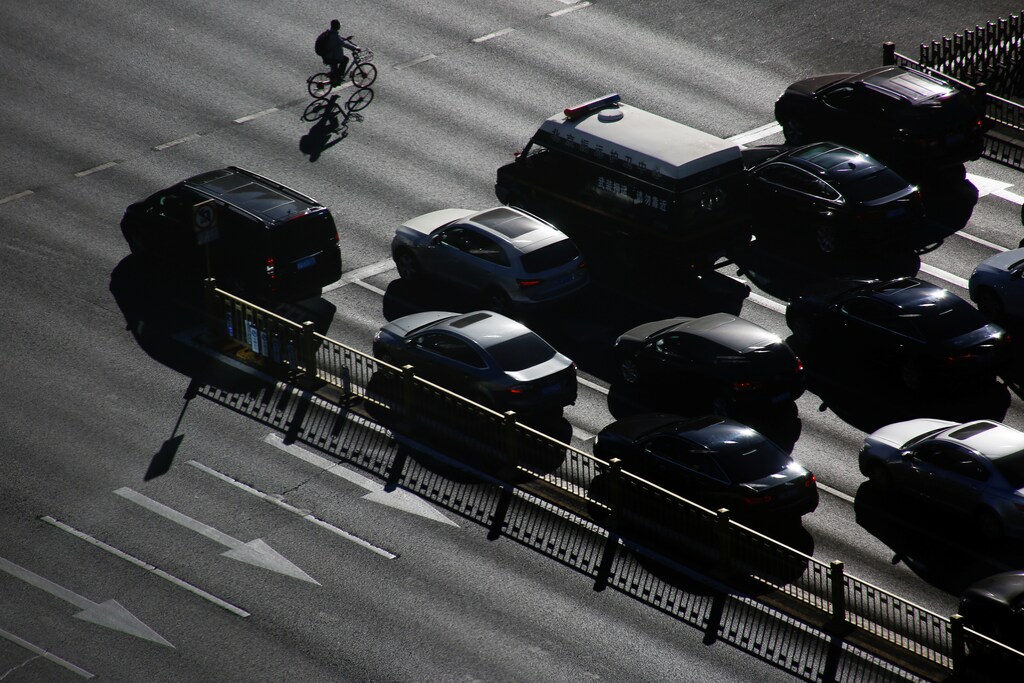 A cyclist rides past cars that are waiting at a traffic light in central Beijing, China October 29, 2018. REUTERS/Thomas Peter - RC1EA3AB28E0