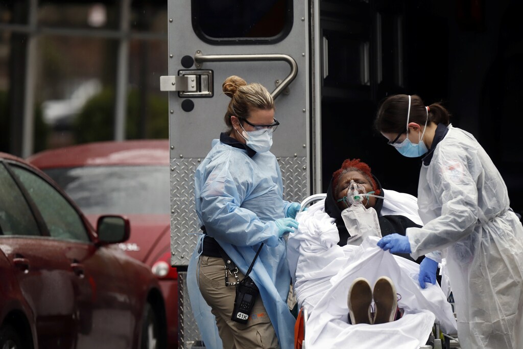 Emergency Medical Technicians (EMT) wearing protective gears wheel a sick patient to a waiting ambulance during the outbreak of coronavirus disease (COVID-19) in New York City, New York, U.S., March 28, 2020. REUTERS/Stefan Jeremiah - RC24TF97DNX6