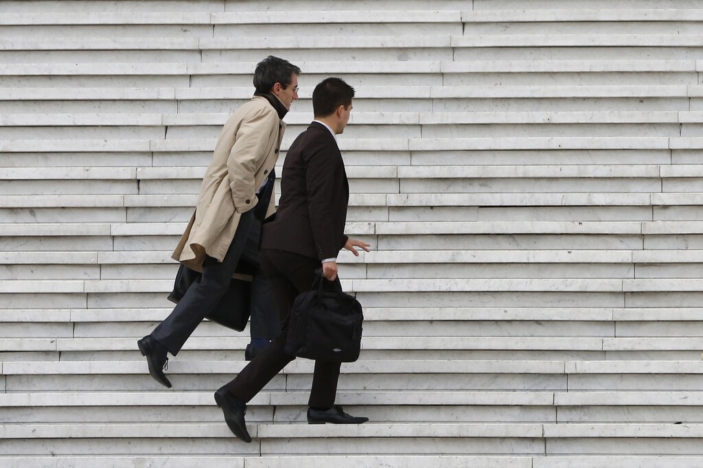 Businessmen carry briefcases as they climb the stairs under the Arche de la Defense in the financial and business district west of Paris October 21, 2014. REUTERS/John Schults (FRANCE - Tags: BUSINESS) - RTR4B05B