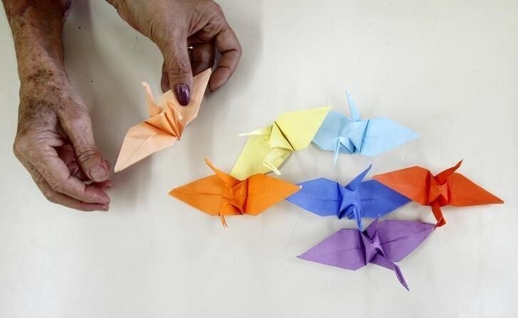 A member of the Japanese community in Peru makes origami cranes to support Japan's earthquake and tsunami victims at the Peruvian Japanese Cultural Center in Lima March 18, 2011. REUTERS/Mariana Bazo (PERU - Tags: SOCIETY DISASTER ENVIRONMENT)