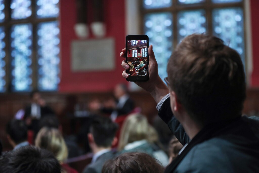 A member of the audience takes a photo on his phone during a speech by NATO Secretary General Jens Stoltenberg at The Oxford Union in the University of Oxford, southern England November 24, 2016. REUTERS/Eddie Keogh - RTST5G6