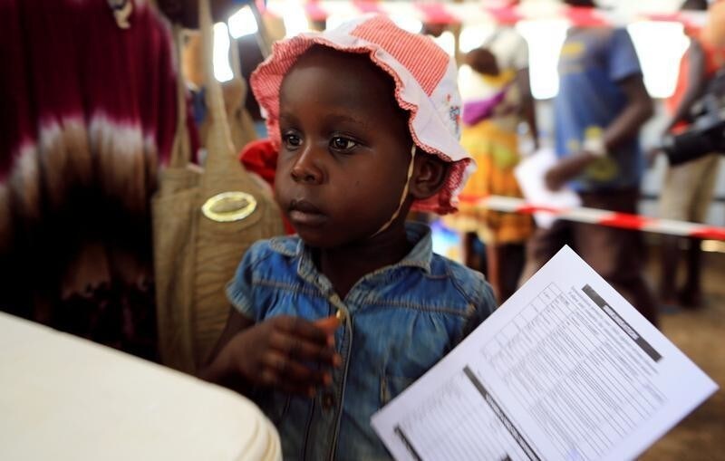 A South Sudanese refugee girl displaced by fighting holds her immunization card on arrival at Imvepi settlement in Arua district, northern Uganda, April 4, 2017. Picture taken April 4, 2017. REUTERS/James Akena