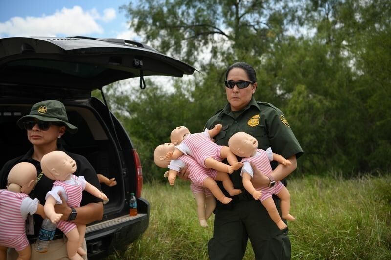A U.S. Border Patrol agent holds infant dolls in preparation for a demonstration during a 'Border Safety Initiative' media event at the U.S.-Mexico border in Mission, Texas, U.S., July 1, 2019. REUTERS/Loren Elliott TPX IMAGES OF THE DAY - RC1587413480