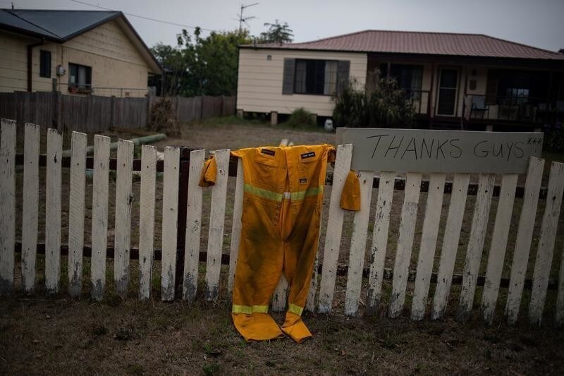 A firefighter's suit hangs on the fence of a property next to a sign that reads "Thanks guys" in the town of Cobargo, New South Wales, Australia, January 12, 2020. REUTERS/Alkis Konstantinidis SEARCH "COBARGO BUSHFIRE" FOR THIS STORY. SEARCH "WIDER IMAGE" FOR ALL STORIES. - RC2BHE91UXRE