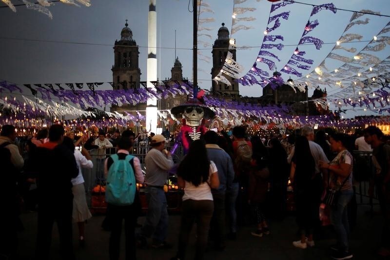 People walk around an altar displaying a "Catrina", a Mexican character also known as "The Elegant Death," as part for the upcoming annual Day of the Dead on November 1 and 2, at the Zocalo in Mexico City, Mexico October 30, 2017.