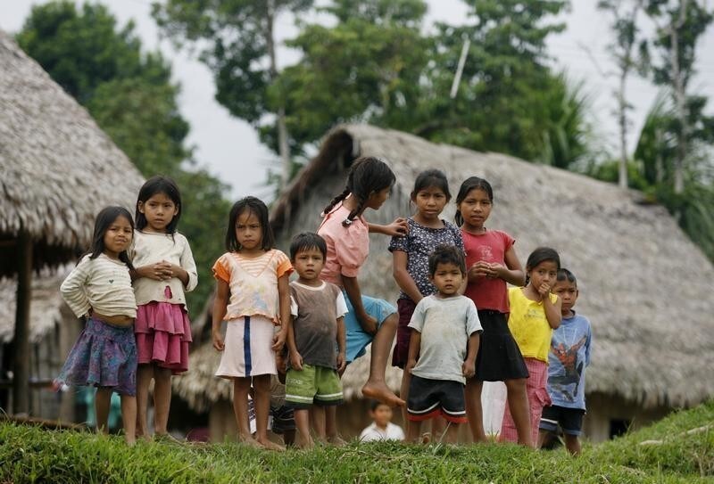 Children stand in a village along the edge of the Pacaya Samiria National Reserve, by the Maranon river in the Amazon jungle March 29, 2008. The Pacaya Samiria National Reserve is located in Peru's Amazon region, 93 miles (150 km) from Iquitos city. The reserve is the largest in Peru and the second largest in the Amazon region. The great size of the reserve assures that it will be ecologically and genetically representative of the region, with an abundance of virtually unchanged areas. Approximately 47,000 people live in the reserve and are located mainly along its edges in villages. REUTERS/Mariana Bazo (PERU) - GM1E43U0WSX01