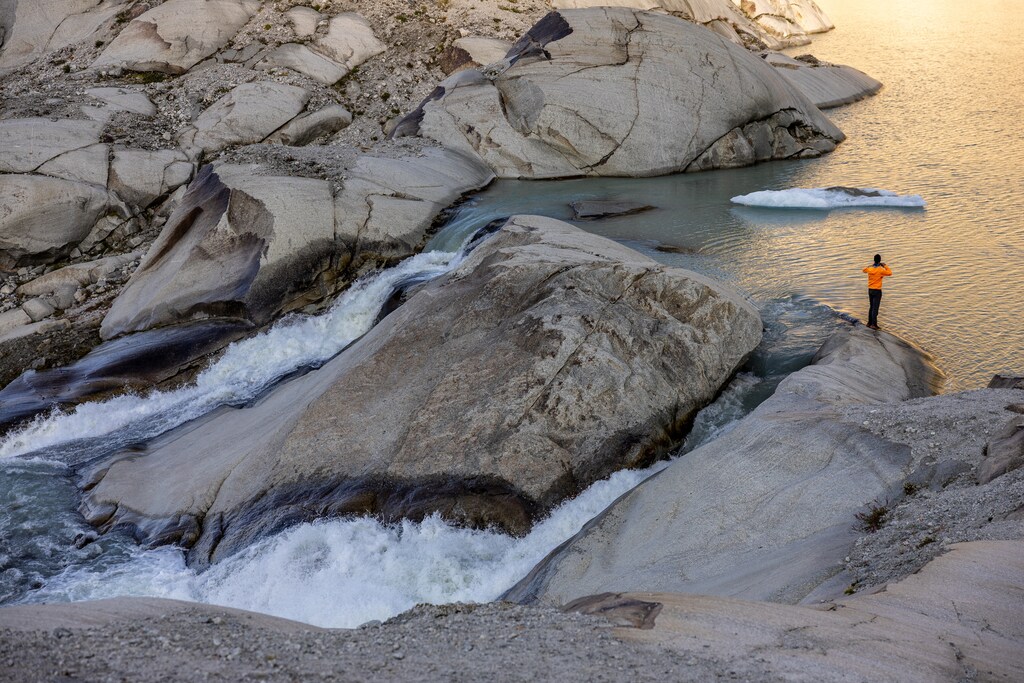 Glaciologist at ETHZ and head of the Glacier Monitoring in Switzerland (GLAMOS) Matthias Huss takes a picture as water flows down the valley at the source of the Rhone and its glacier amid climate change in Obergoms, Switzerland, August 27, 2024: Osmotic energy is a carbon-free renewable source with global potential