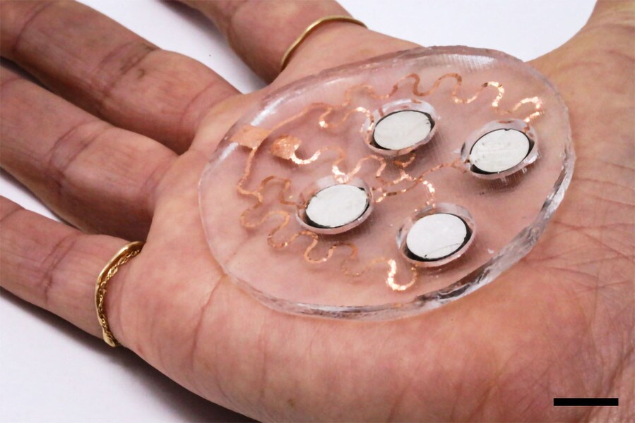 A hand holding a patch that delivers drugs into the skin through ultrasonic waves