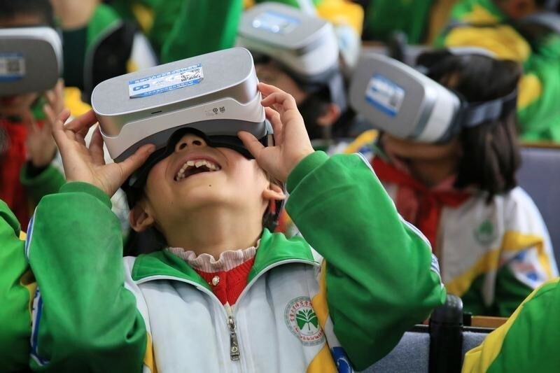 Primary school students wear virtual reality (VR) headsets inside a classroom in Xiangxi Tujia and Miao Autonomous Prefecture, Hunan province, China March 14, 2018. Picture taken March 14, 2018.