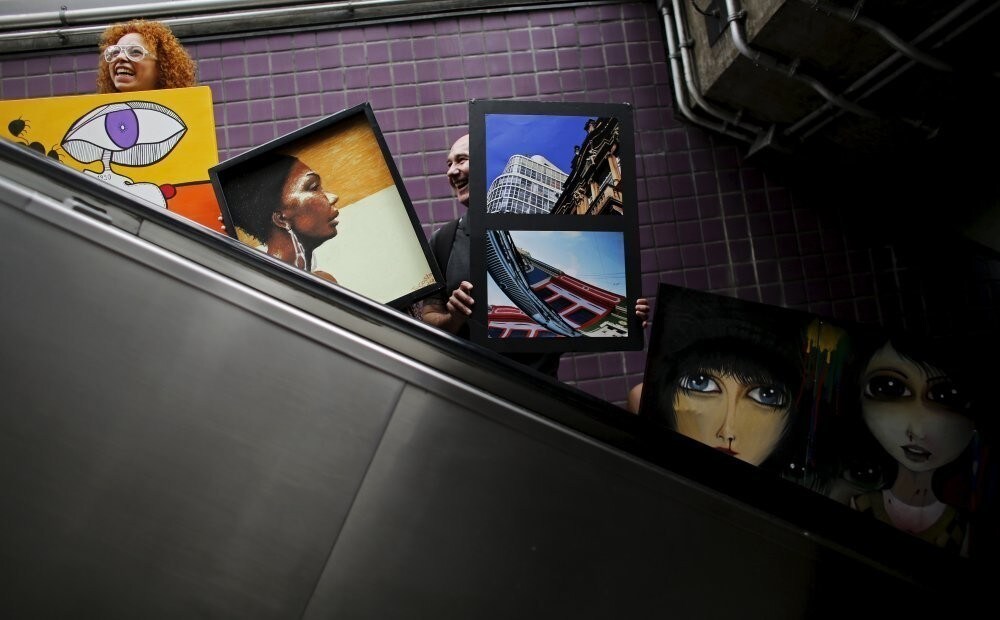Artists carry their creations on an escalator in Consolacao subway near Paulista avenue during a mobile exhibition named "Walking Gallery", in Sao Paulo May 23, 2015. REUTERS/Nacho Doce