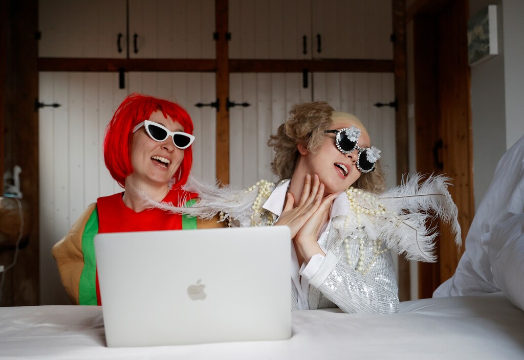 Emily dressed as Elton John and Molly as Lady Gaga watch the concert One World: Together At Home, as the spread of the coronavirus disease (COVID-19) continues, Henton, Britain, April 18, 2020. REUTERS/Eddie Keogh - RC267G95RC62